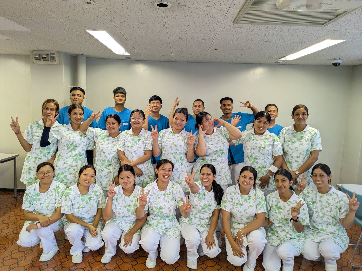 建設現場でヘルメットと安全ハーネスを着用して活躍する外国人材3名の様子