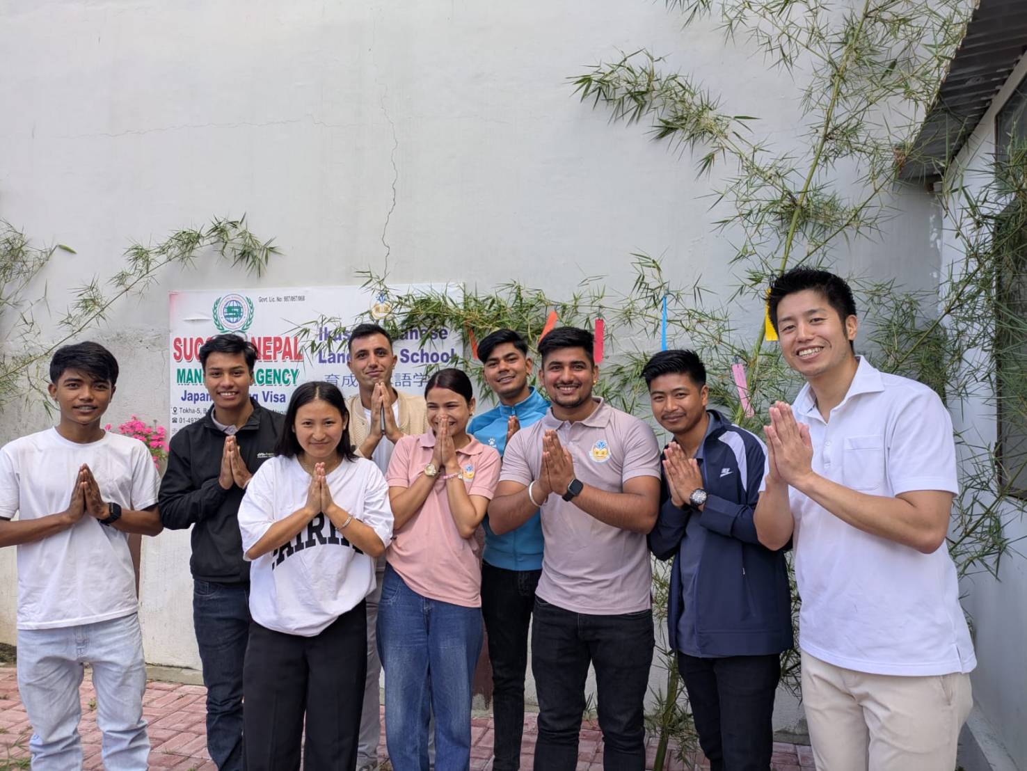 げんき大阪のネパール人スタッフがコミュニティで笑顔でナマステしている様子