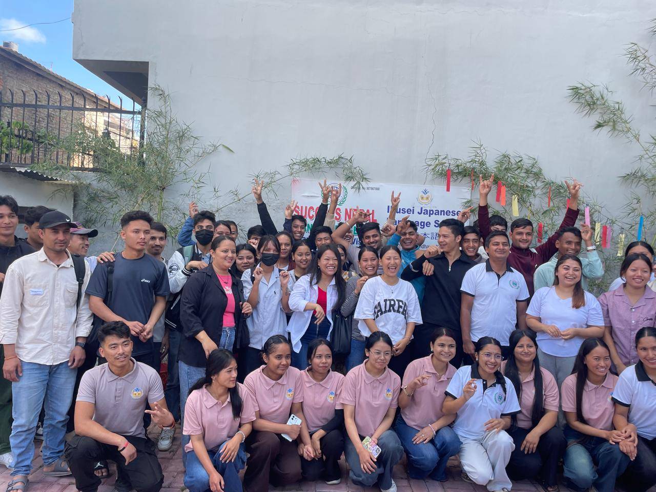 飲食店の厨房で白いユニフォームを着て働く外国人スタッフ2名の様子